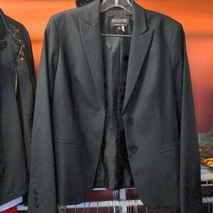 Jacket no pockets. Two buttons on front and three buttons on sleeves.